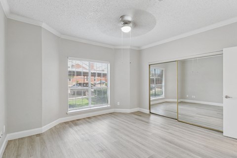 A spacious room with a sliding glass door leading to a balcony.