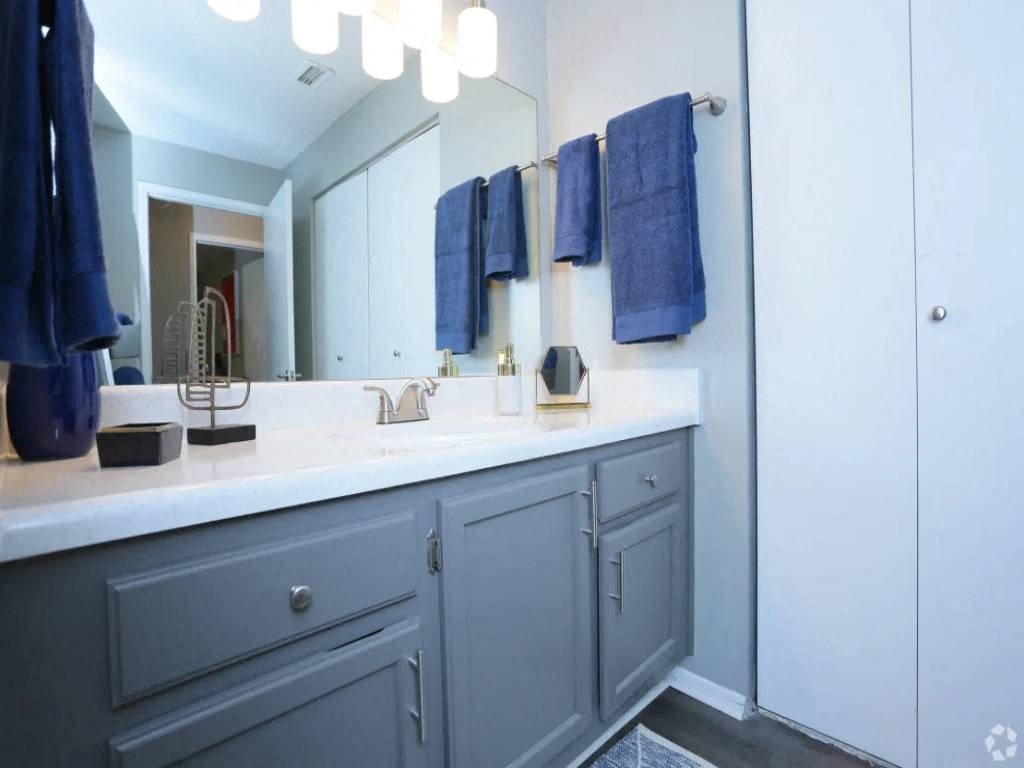 a bathroom with a sink and a mirror and blue towels