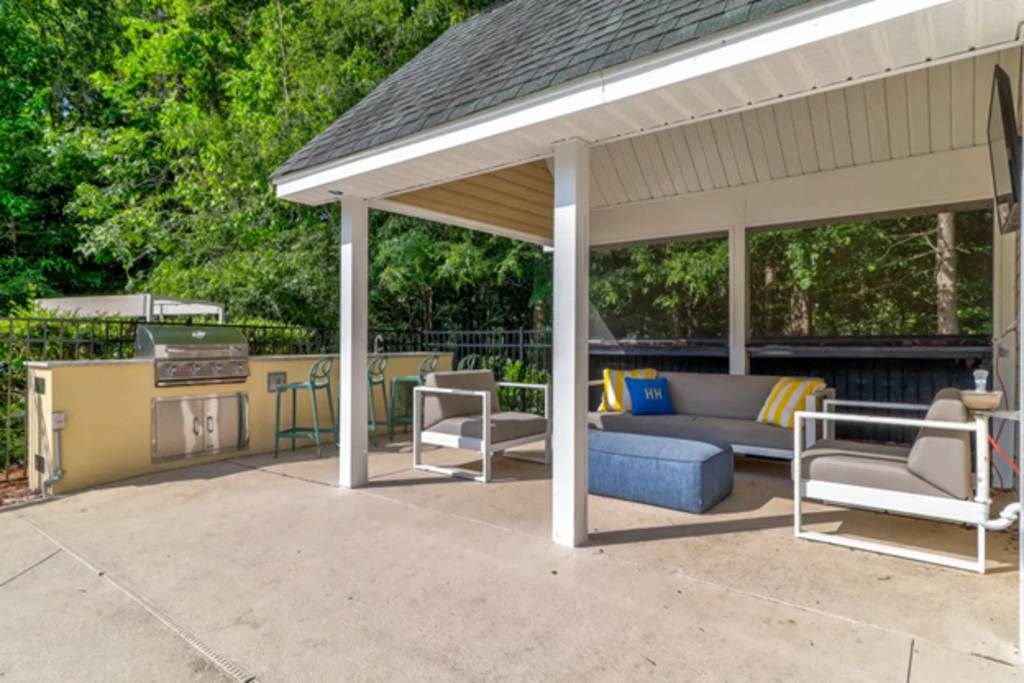 a patio with a couch chairs and a grill at Enclave at West Ashley Apartments, Charleston, SC, 29414