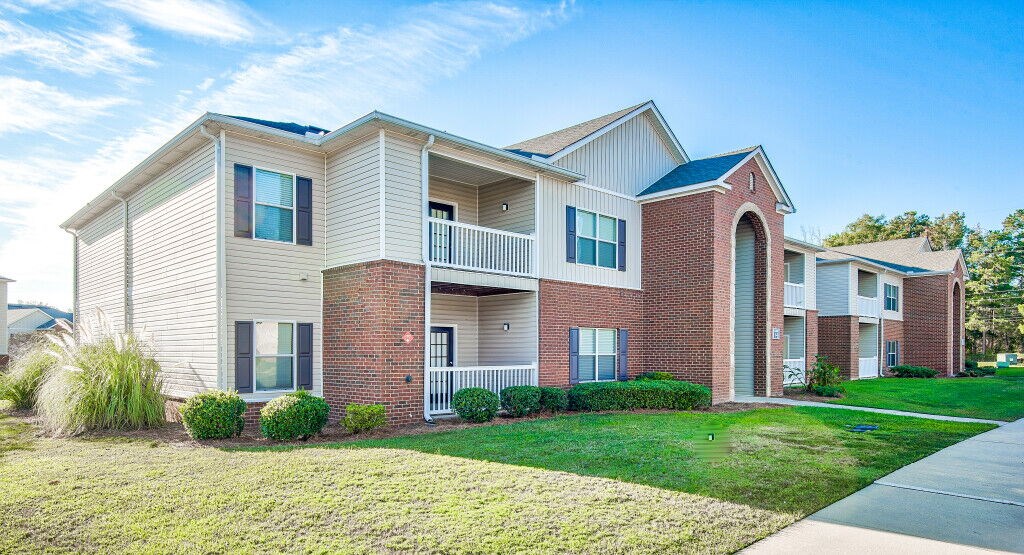 A row of townhouses with a clear blue sky above them.