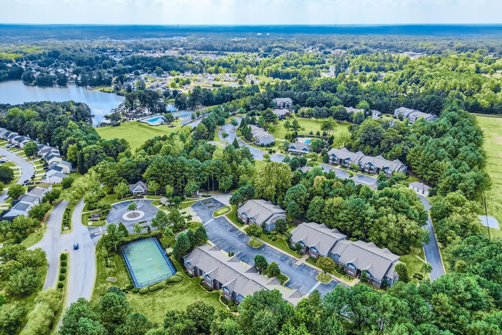 an aerial view of a neighborhood with houses and a pond