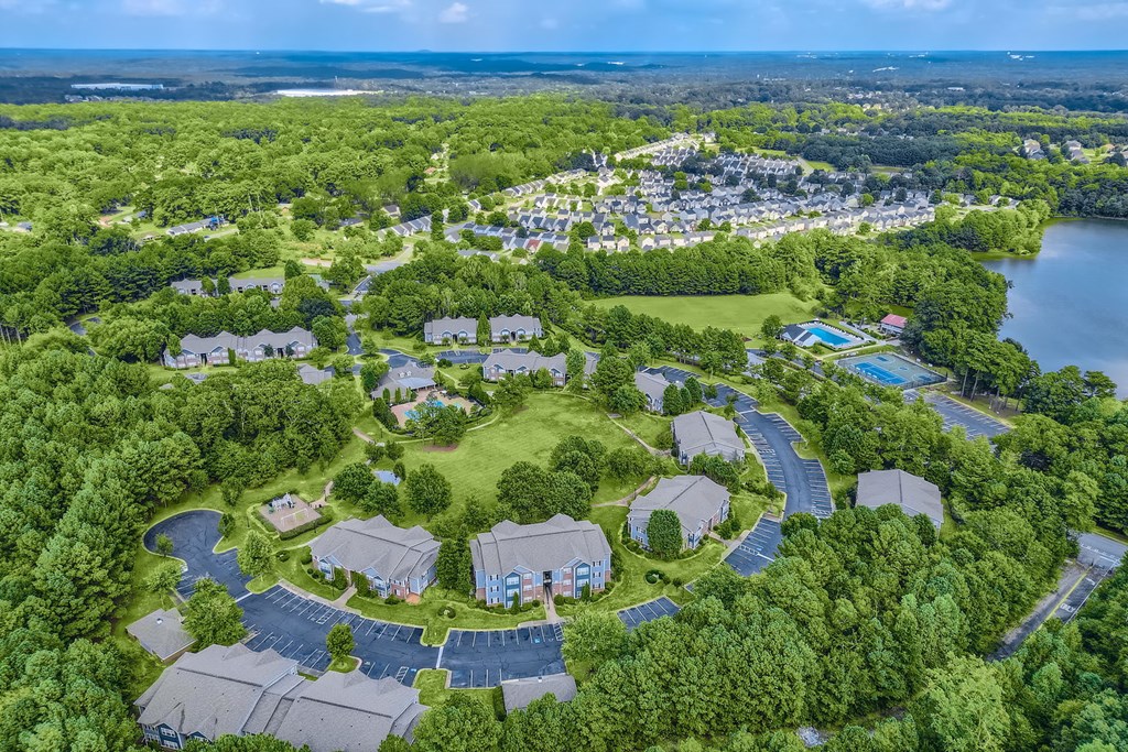 a aerial view of a park with houses and a body of water