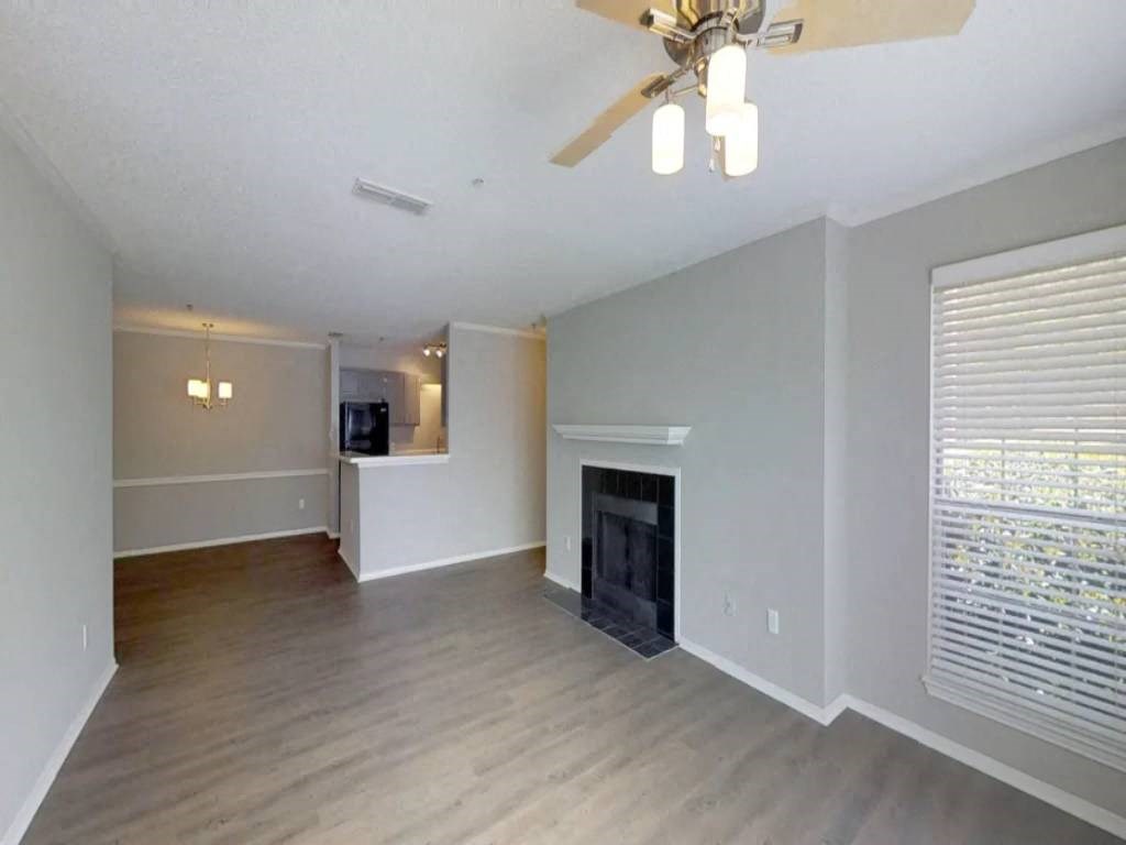 a living room with a fireplace and a ceiling fan
