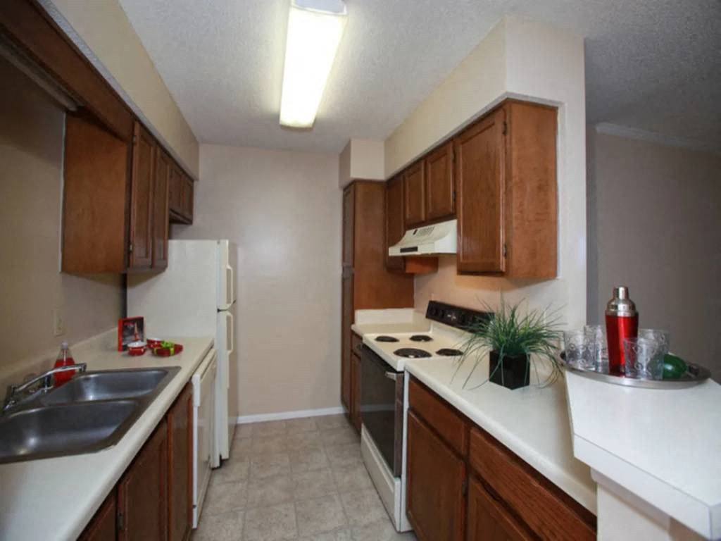a kitchen with white counter tops and wooden cabinets