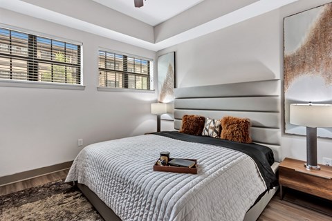 A bedroom with a large bed and a wooden tray on top of it.