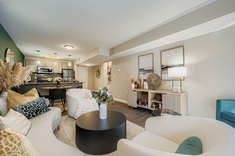 A living room with a black coffee table and white chairs.