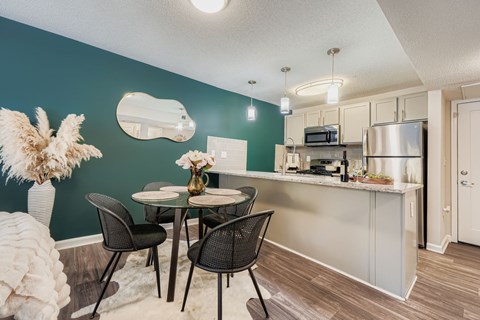 A kitchen with a dining table and chairs.