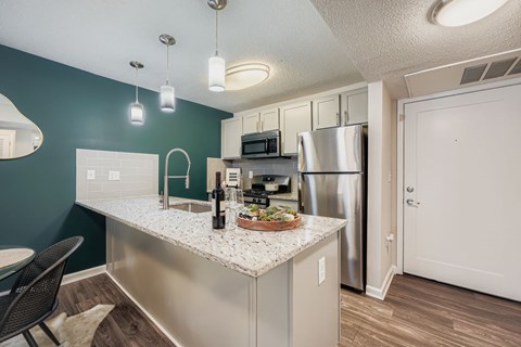 A kitchen with a stainless steel refrigerator and a white countertop.