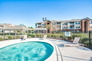 A pool in front of a building with a sign that says "Reserve Now".