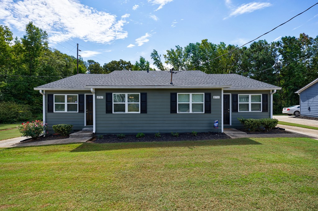 A house with a grey roof and a small front yard.