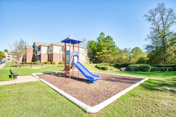 A playground with a blue slide and a red and blue structure.