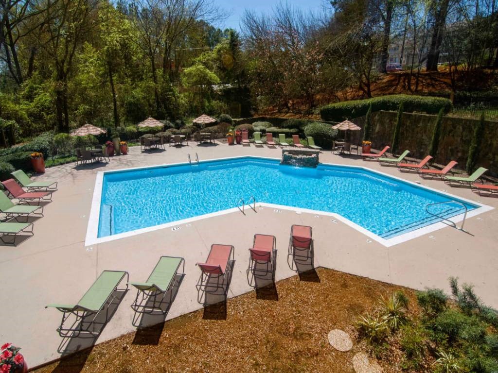 a swimming pool with chairs and chairs around it