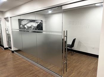 a conference room with glass doors and a picture on the wall