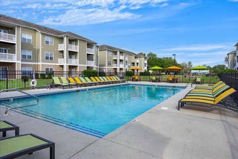A swimming pool in front of apartment buildings.
