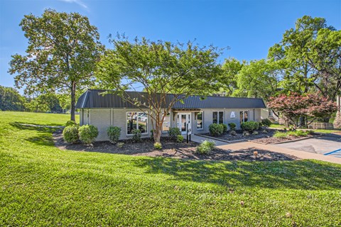 a house with a driveway and a tree in front of it