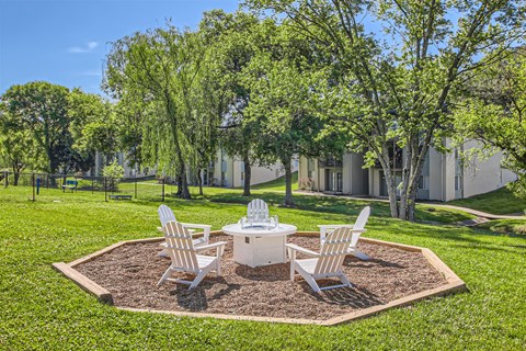 a patio with a table and chairs in the grass