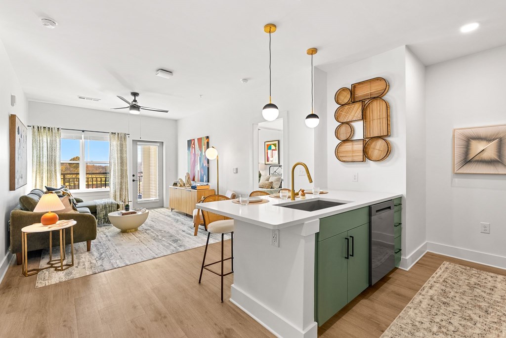 A modern kitchen with green cabinets and a white countertop.