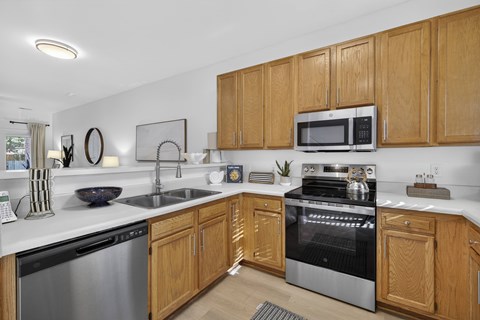 A modern kitchen with wooden cabinets and stainless steel appliances.