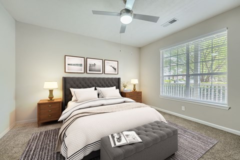 A bedroom with a large bed and a ceiling fan.