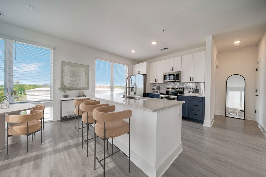 an open kitchen and dining area with a large island and bar stools