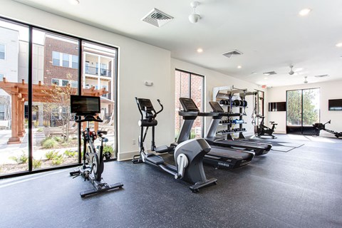 the gym has plenty of exercise equipment and large windows at The Indigo Apartments, Canton