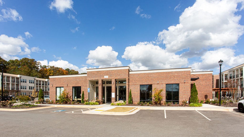 the front of a brick building with a parking lot at The Indigo Apartments, Canton, 30114