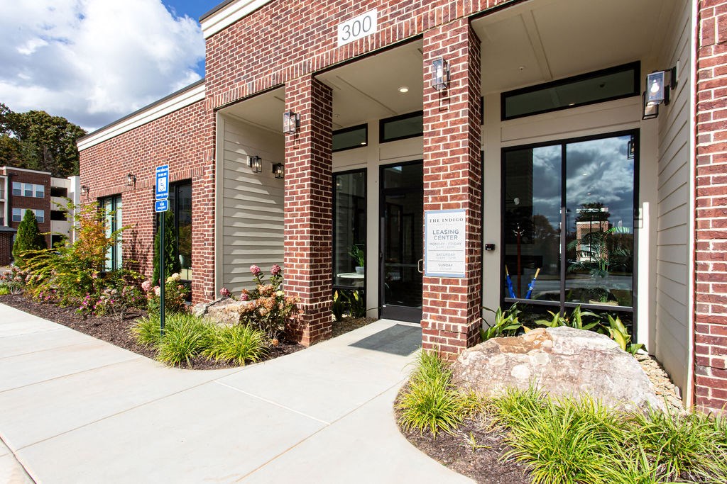 the front of a brick building with glass doors at The Indigo Apartments, Canton, GA