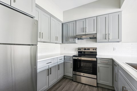 A modern kitchen with a stainless steel refrigerator and oven.