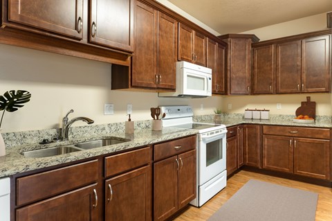 A kitchen with brown cabinets and a white stove top oven.