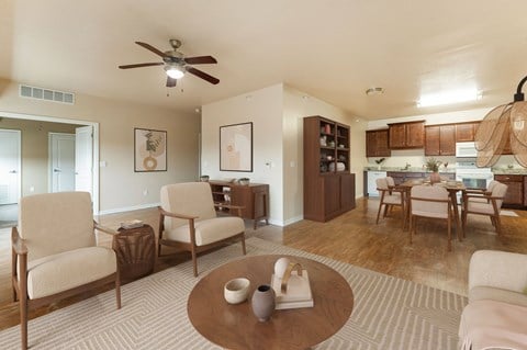 A living room with a brown coffee table and beige chairs.