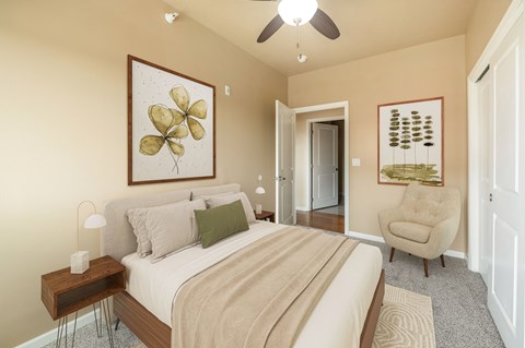 A bedroom with a large bed and a ceiling fan.