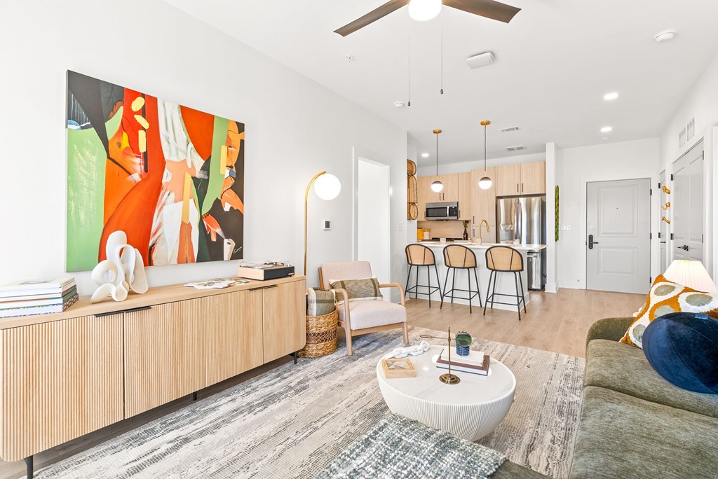 A living room with a large painting on the wall and a wooden cabinet.