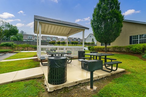 A picnic area with a table and a trash can.