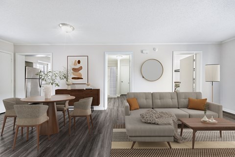 A modern living room with a grey sofa and wooden chairs.