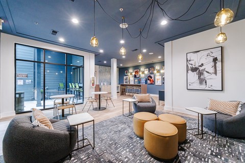 A modern lounge area with a variety of seating options and a large window.