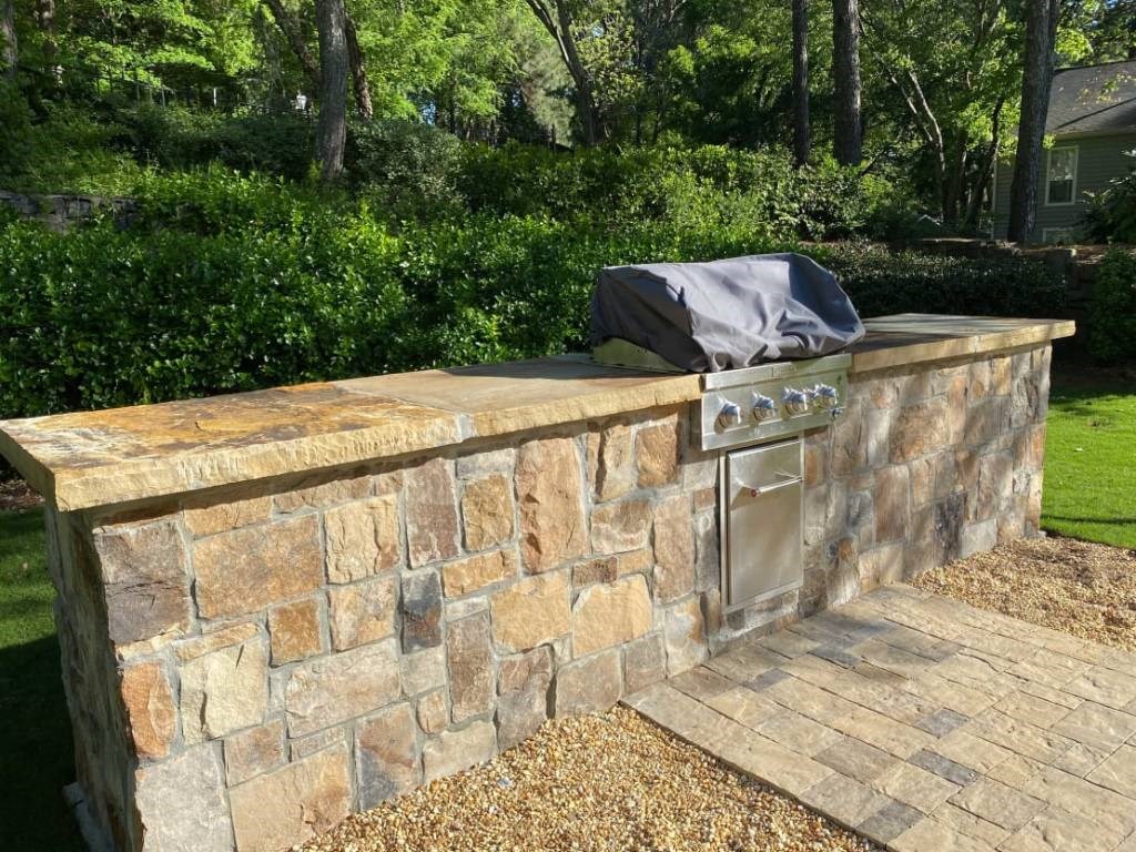 a stone bar with a stainless steel stove on a patio