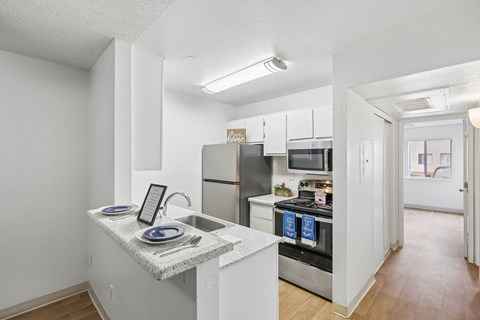 A kitchen with a white counter and stainless steel appliances.