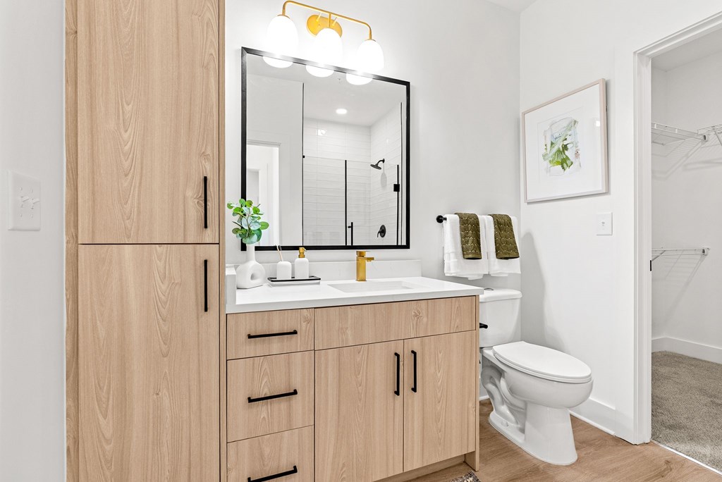 A bathroom with a wooden vanity and white toilet.