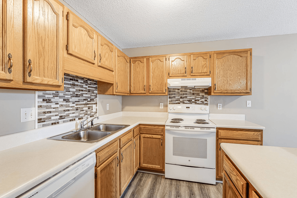 a kitchen with white appliances and wooden cabinets