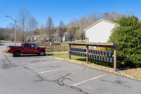 a red truck parked in a parking lot in front of a fence