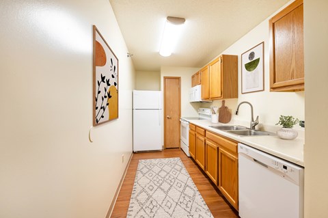 A kitchen with wooden cabinets and a white dishwasher.