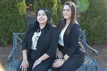 two women sitting on a bench posing for a picture at Breckinridge Vue, Duluth, GA, 30096
