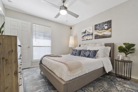 A bedroom with a large bed and a ceiling fan.