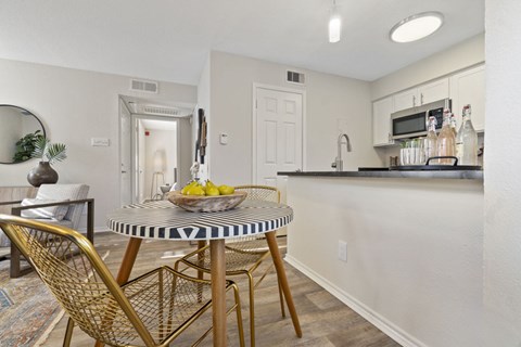 A kitchen with a table and chairs.
