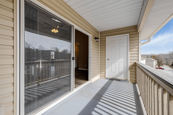 the front porch of a home with a white door