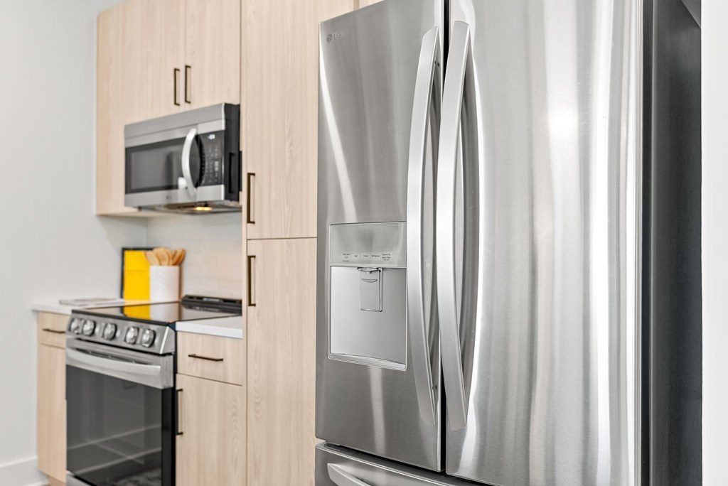 A modern kitchen with a stainless steel refrigerator and oven.