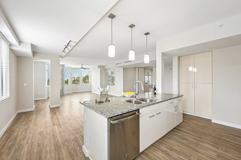 A modern kitchen with a large island and wooden floors.