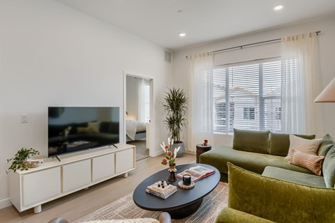 A living room with a television, a sofa, and a coffee table.