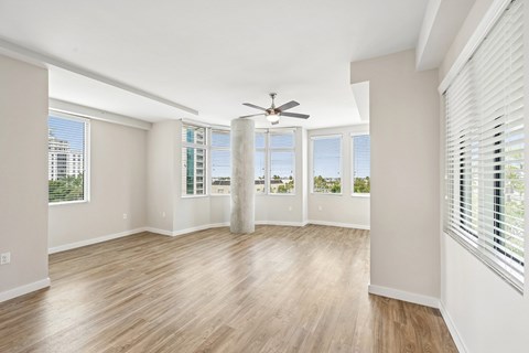 A room with a ceiling fan and wooden flooring.