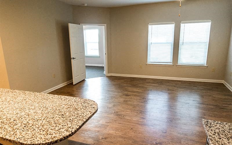 an empty living room with wood floors and a door